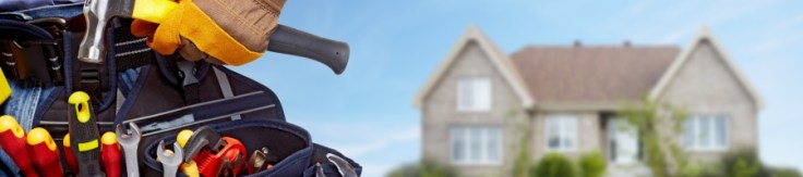 Builder handyman with construction tools. House renovation background.